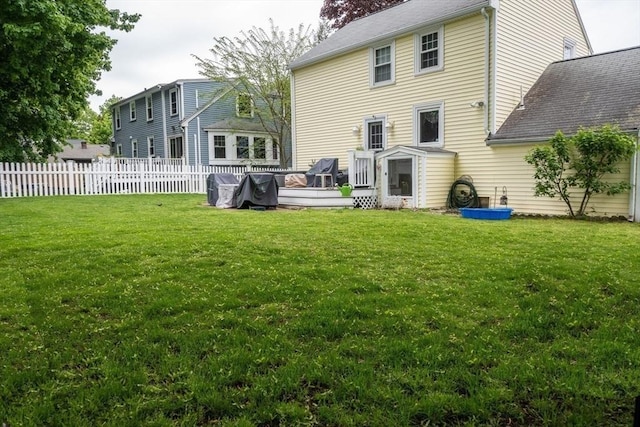 back of property with a deck and a yard