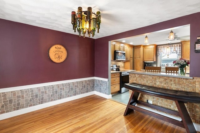 kitchen featuring appliances with stainless steel finishes, light hardwood / wood-style flooring, and a chandelier