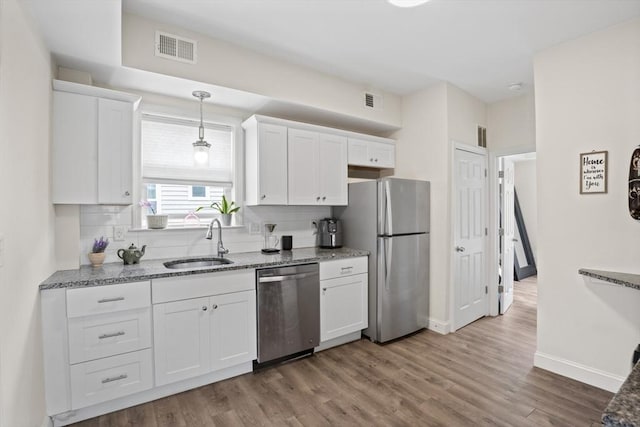 10 Elliott Pl Unit 3F, Peabody, MA 01960 - kitchen featuring appliances with stainless steel finishes, white cabinetry, tasteful backsplash, and wood finished floors
