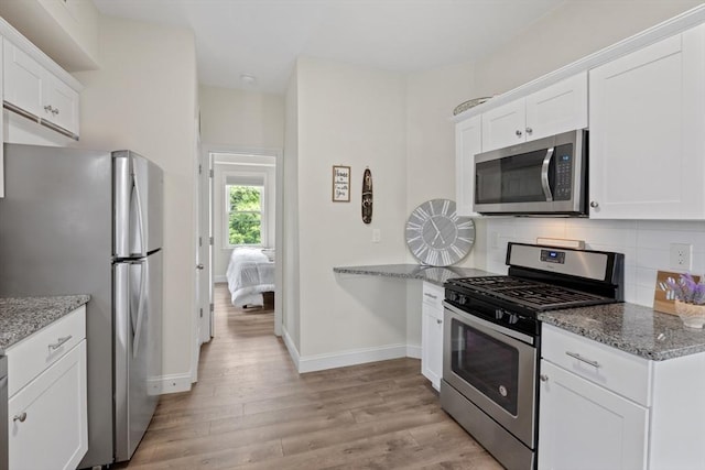 10 Elliott Pl Unit 3F, Peabody, MA 01960 - kitchen with appliances with stainless steel finishes, light wood-style floors, backsplash, and white cabinets