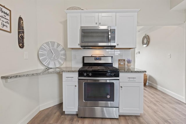 10 Elliott Pl Unit 3F, Peabody, MA 01960 - kitchen with stainless steel appliances, light wood-style flooring, white cabinetry, and dark stone countertops
