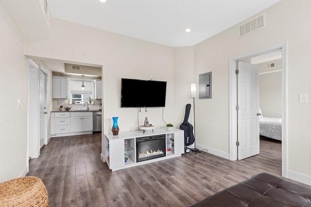 10 Elliott Pl Unit 3F, Peabody, MA 01960 - living area featuring dark wood-style flooring, electric panel, a glass covered fireplace, and recessed lighting