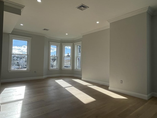 unfurnished room with dark hardwood / wood-style flooring, a wealth of natural light, and crown molding