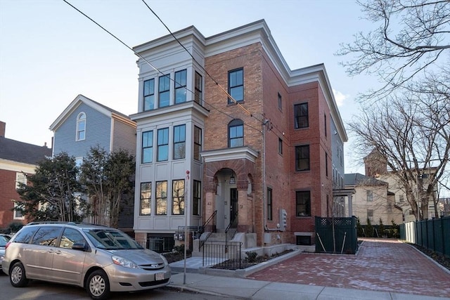 multi unit property featuring brick siding and fence