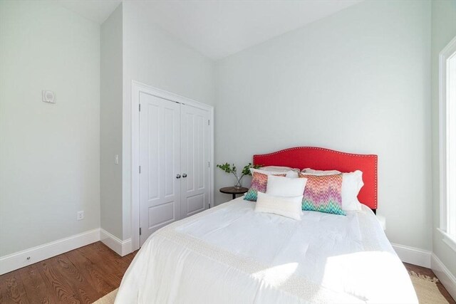 bedroom featuring a closet, baseboards, and wood finished floors