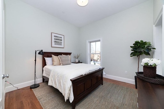 bedroom featuring baseboards and dark wood finished floors