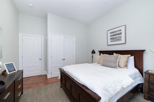 bedroom with dark wood-type flooring and a closet