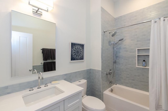 bathroom featuring vanity, tile walls, toilet, and shower / bath combo with shower curtain