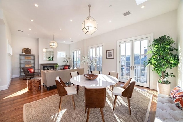 dining area with light wood finished floors, a fireplace, visible vents, and recessed lighting