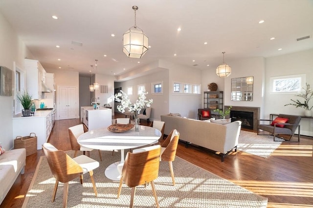 dining area with light wood finished floors, a fireplace, visible vents, and recessed lighting