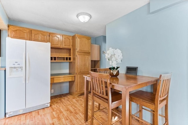 dining area featuring light wood-style floors and built in study area