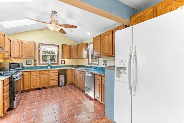 kitchen featuring ceiling fan, appliances with stainless steel finishes, a sink, light countertops, and lofted ceiling
