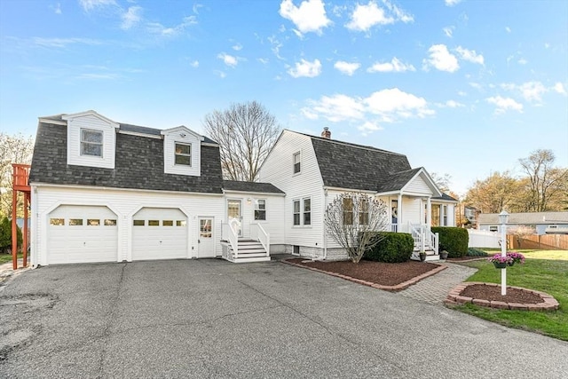 dutch colonial featuring fence, a shingled roof, a gambrel roof, and aphalt driveway