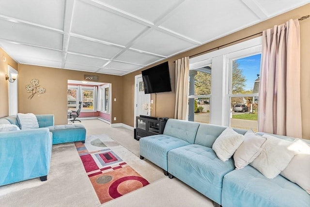 carpeted living area featuring baseboards, plenty of natural light, and coffered ceiling