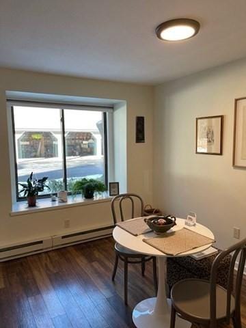 dining space with plenty of natural light, baseboard heating, and dark hardwood / wood-style floors