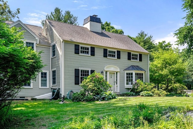 colonial-style house featuring a front lawn