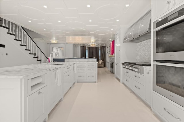 68 W Rutland Sq, Boston, MA 02118 - kitchen featuring a sink, stainless steel appliances, white cabinets, light stone counters, and concrete floors