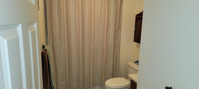 full bath featuring a shower with curtain, toilet, and vanity