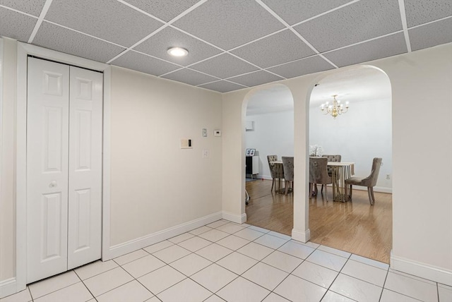 18 Shadowbrook Ln Unit 40, Milford, MA 01757 - dining room featuring arched walkways, a paneled ceiling, a chandelier, baseboards, and light tile patterned floors