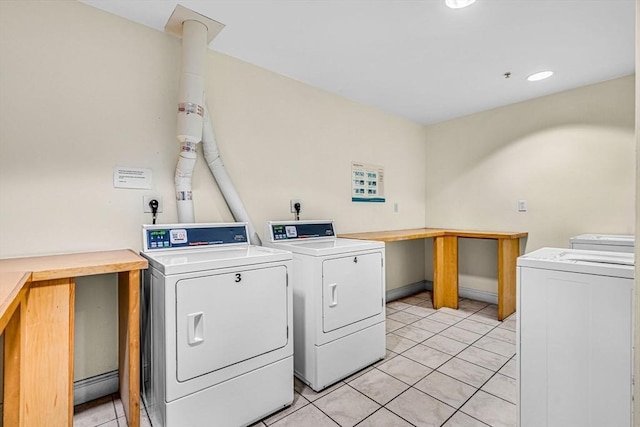 laundry area featuring light tile patterned floors, washing machine and dryer, and a baseboard heating unit