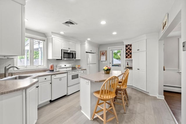 150 Academy St, Braintree, MA 02184 - kitchen featuring white appliances, a baseboard radiator, a sink, light wood-style floors, and recessed lighting