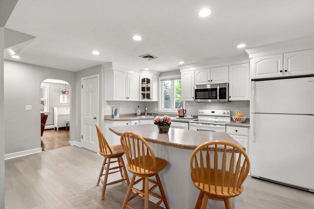 150 Academy St, Braintree, MA 02184 - kitchen with white appliances, arched walkways, a sink, a kitchen breakfast bar, and recessed lighting