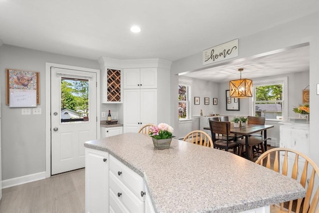 150 Academy St, Braintree, MA 02184 - kitchen featuring plenty of natural light, light wood finished floors, white cabinets, a kitchen island, and recessed lighting