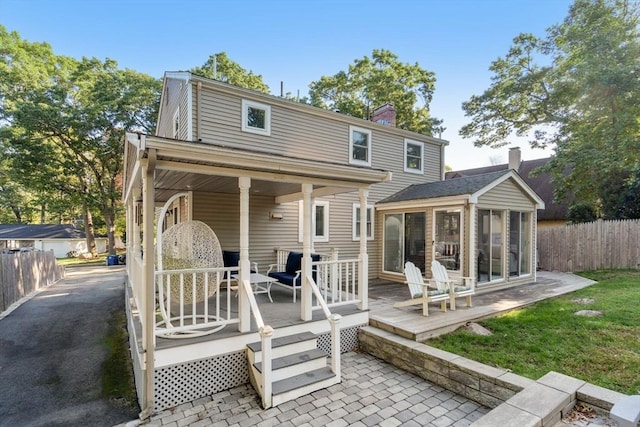150 Academy St, Braintree, MA 02184 - rear view of house featuring a sunroom, a chimney, and a wooden deck