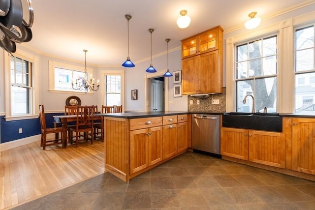 kitchen featuring sink, hanging light fixtures, ornamental molding, kitchen peninsula, and stainless steel dishwasher