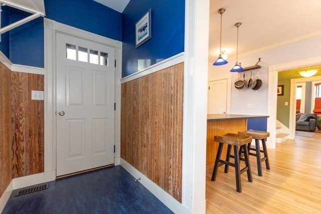 entrance foyer featuring hardwood / wood-style flooring and wooden walls