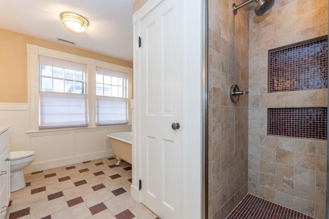 bathroom featuring toilet, vanity, and a tile shower