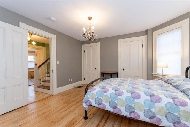 bedroom featuring wood-type flooring and an inviting chandelier