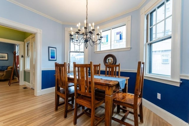 dining area featuring a chandelier, crown molding, and light hardwood / wood-style floors