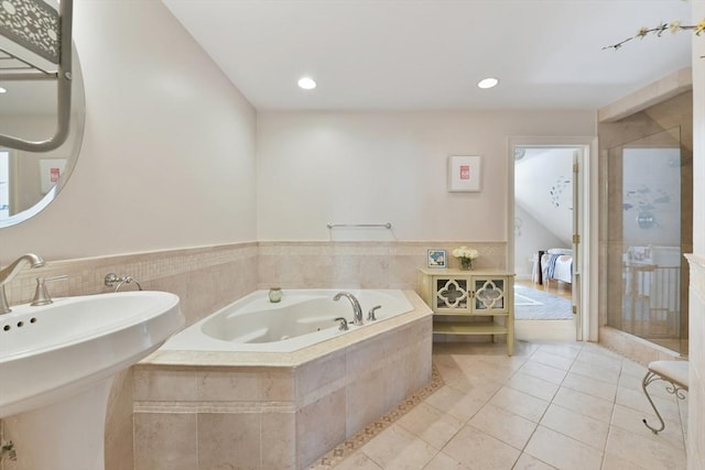 bathroom featuring a stall shower, a sink, tile patterned floors, a bath, and recessed lighting