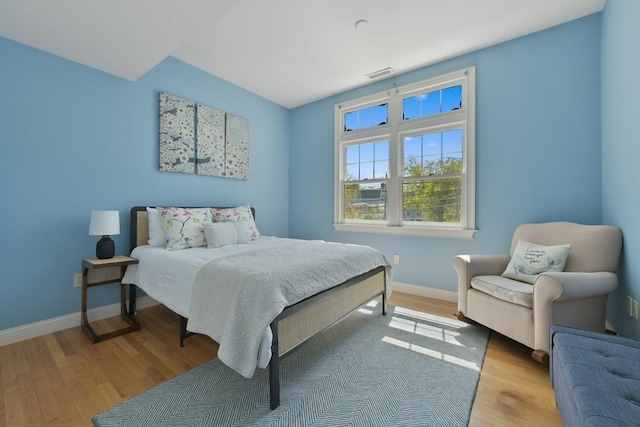 bedroom featuring visible vents, wood finished floors, and baseboards