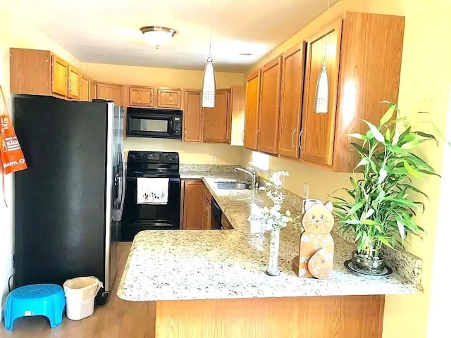 167 Orient St, Worcester, MA 01604 - kitchen featuring black appliances, brown cabinets, wood finished floors, and hanging light fixtures