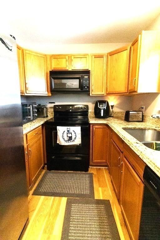 167 Orient St, Worcester, MA 01604 - kitchen with black appliances, light wood-style flooring, and light stone countertops