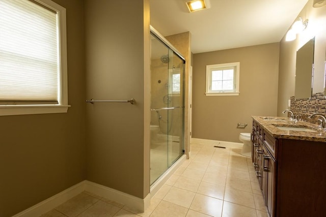 bathroom with toilet, a stall shower, vanity, tile patterned flooring, and baseboards