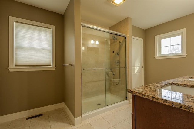 full bath featuring a stall shower, visible vents, baseboards, tile patterned flooring, and vanity