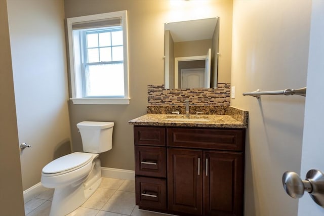 bathroom featuring baseboards, decorative backsplash, toilet, tile patterned floors, and vanity