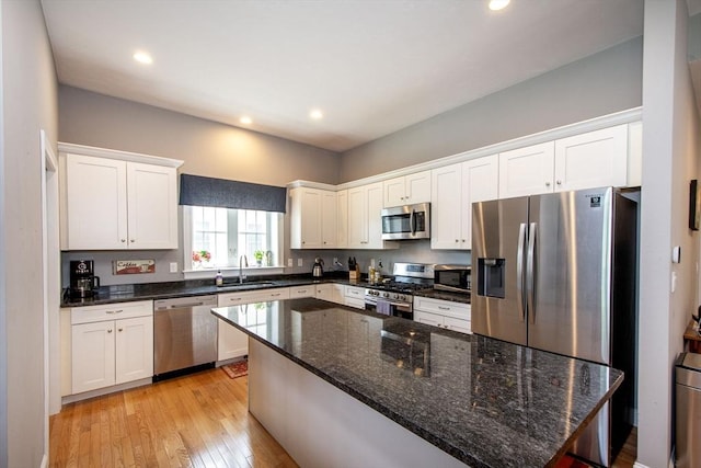 82 Snowbird Ave, Weymouth, MA 02190 - kitchen featuring stainless steel appliances, white cabinets, light wood-type flooring, recessed lighting, and dark stone counters