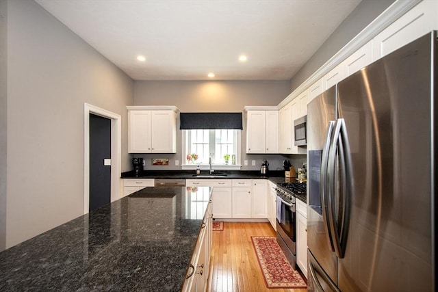 82 Snowbird Ave, Weymouth, MA 02190 - kitchen featuring appliances with stainless steel finishes, white cabinets, light wood-type flooring, recessed lighting, and dark stone counters