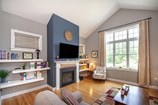 82 Snowbird Ave, Weymouth, MA 02190 - living room featuring wood finished floors, vaulted ceiling, and a glass covered fireplace