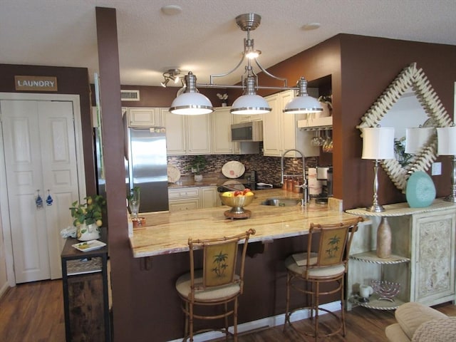 50 S Common St Unit 311, Lynn, MA 01902 - kitchen with appliances with stainless steel finishes, a peninsula, a sink, backsplash, and dark wood-style flooring