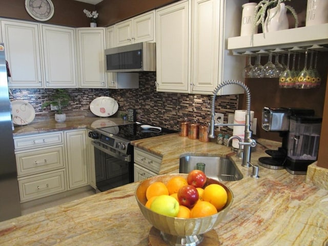 50 S Common St Unit 311, Lynn, MA 01902 - kitchen with stainless steel appliances, a sink, tasteful backsplash, and white cabinets