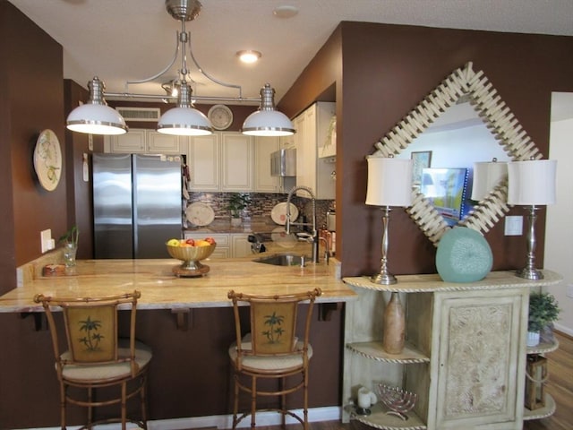 50 S Common St Unit 311, Lynn, MA 01902 - kitchen with freestanding refrigerator, a sink, a peninsula, and tasteful backsplash