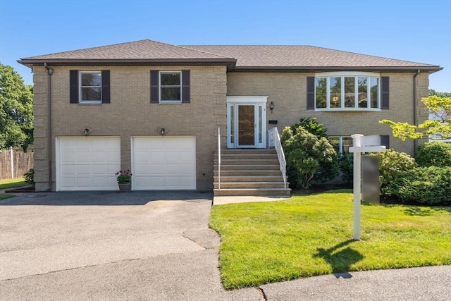 6 Gavin Cir, Stoneham, MA 02180 - split foyer home with a garage, a front lawn, concrete driveway, brick siding, and a shingled roof