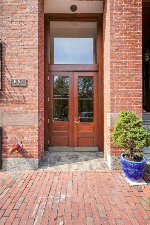 view of exterior entry featuring french doors and brick siding