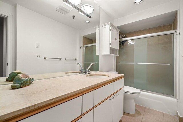 full bath featuring vanity, tile patterned floors, a shower with door, and toilet