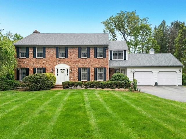 8 Adams Rd, Grafton, MA 01519 - colonial home featuring an attached garage, asphalt driveway, a front lawn, and a chimney